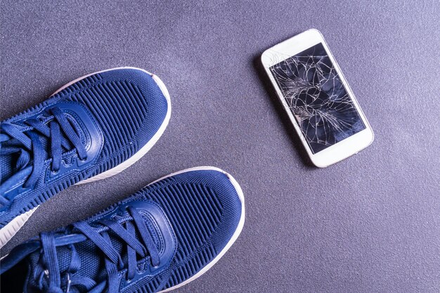 Attrezzature per il fitness con scarpe da ginnastica e smartphone