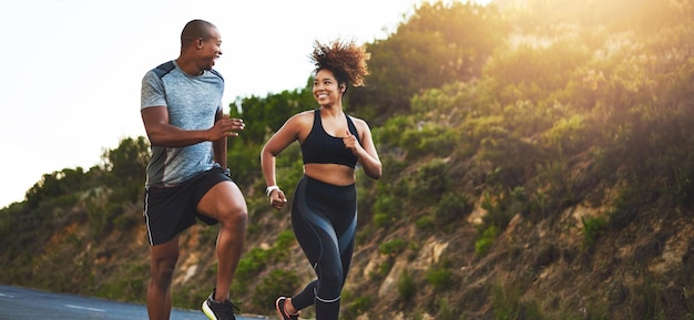 Photo fitness exercise and couple running in nature by a mountain training for a race marathon or competition sports health and athletes or runners doing an outdoor cardio workout together at sunset