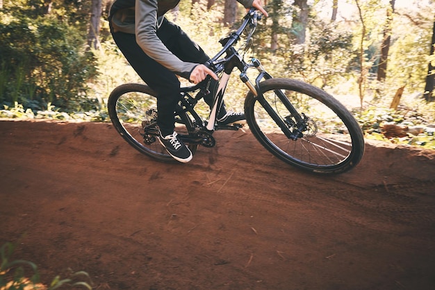 Fitness fietstraining en man buiten op een bospad met extreem en oefenavontuur Fiets fietsen en sport van een atleet met hoge snelheid en natuurheuvel voor sporttraining en actie