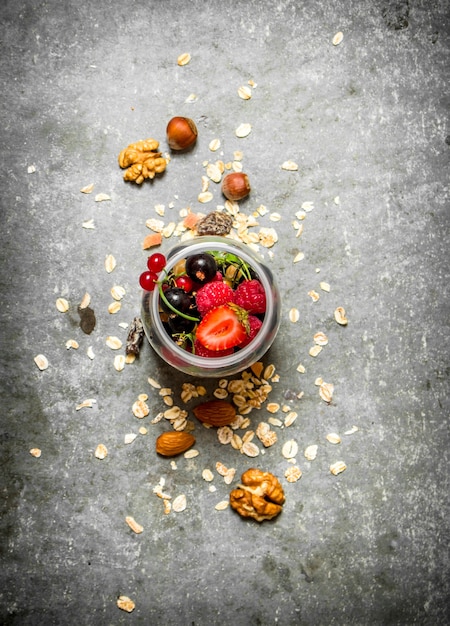 Fitness food. Berries with muesli and nuts. On the stone table.