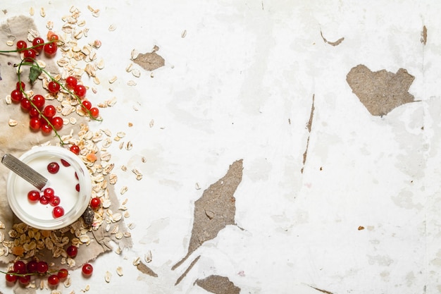 Fitness food. Milk cream with oats and ripe currants. On rustic table.