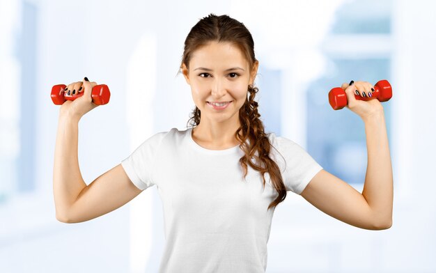 Fitness girl - attractive young woman working out with dumbbells