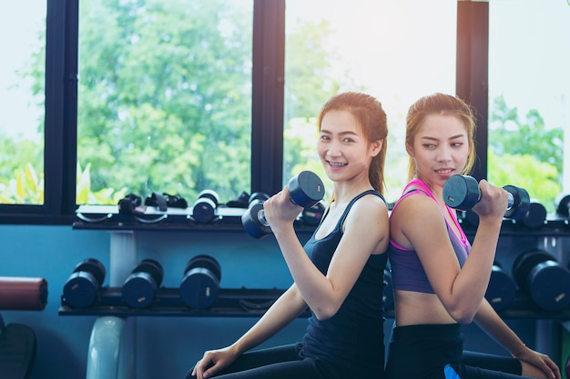 Photo fitness girl exercising with barbell in gym.