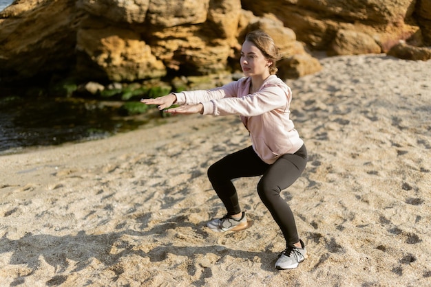 Fitness Girl making workout leg at the beach