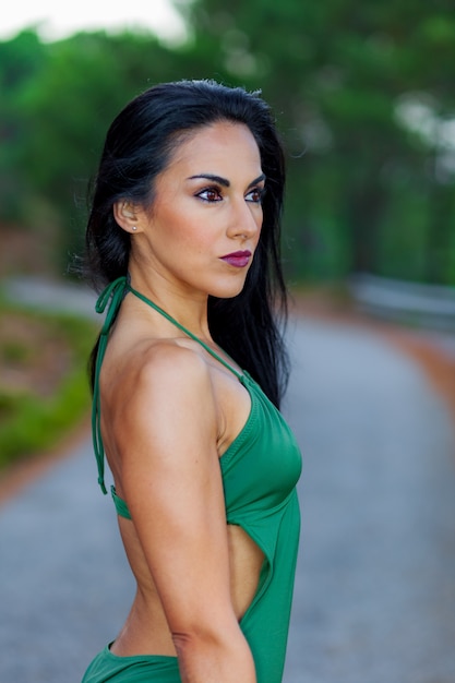 Fitness girl posing with a beautiful green swimsuit