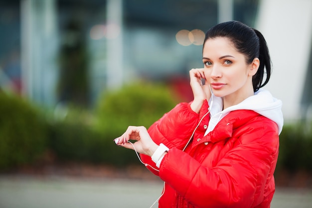 Ragazza fitness. musica corrente e d'ascolto della ragazza abbastanza sportiva all'aperto. stile di vita sano nella grande città