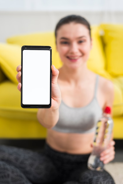 Photo fitness girl showing mobile phone