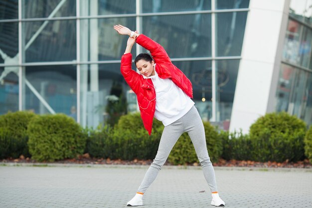 Fitness girl Young sports woman stretching in the modern city Healthy lifestyle in the big city