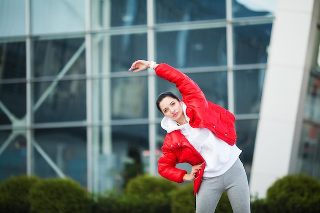 Fitness girl Young sports woman stretching in the modern city Healthy lifestyle in the big city