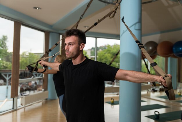 Fitness groep mensen doen Suspension Training Trx oefeningen met riemen in een sportschool