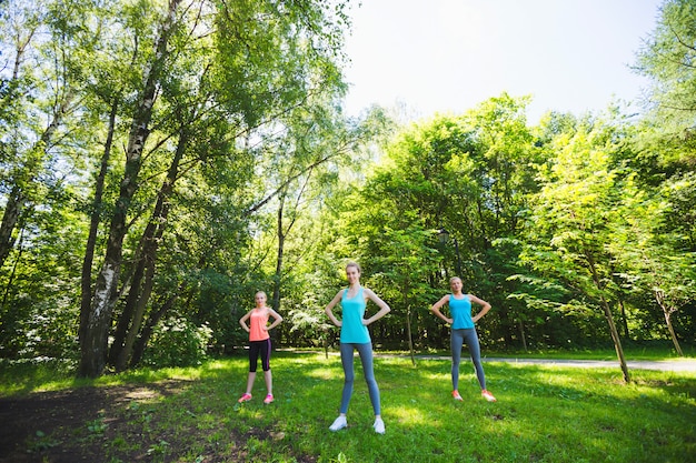 Fitness group doing yoga in park on a sunny day