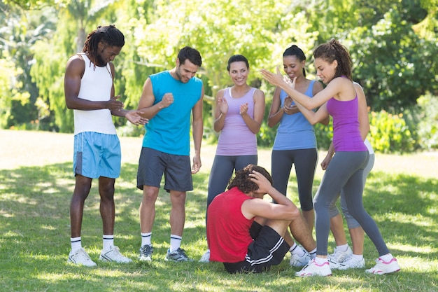 Fitness group encouraging man doing sit ups