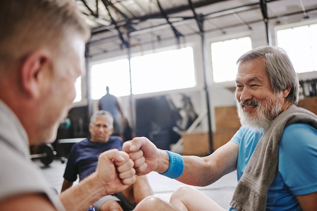 Fitness gym and men with fist bump for senior support personal trainer goals and exercise progress Japanese or asian elderly person with teamwork achievement and success hand sign for training