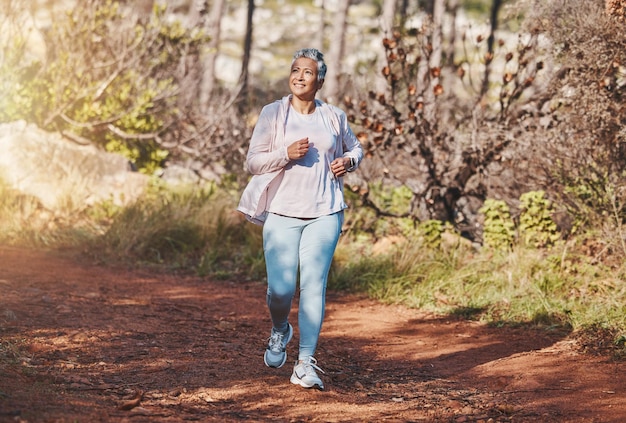 Photo fitness happy or old woman running in nature cardio training exercise or workout in new zealand runner freedom or healthy senior person smiles with pride body goals or motivation in summer