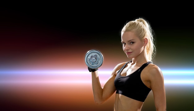 fitness, healthcare and dieting concept - young sporty woman with heavy steel dumbbell