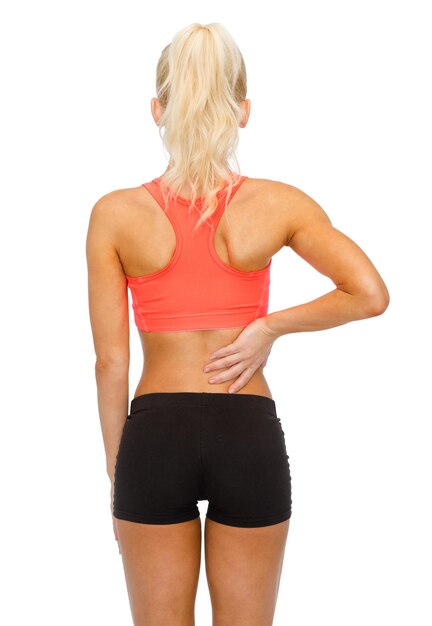 fitness, healthcare and medicine concept - sporty woman touching her back