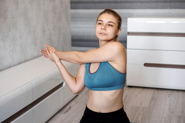 Fitness, home and diet concept. Smiling girl streching on floor at home