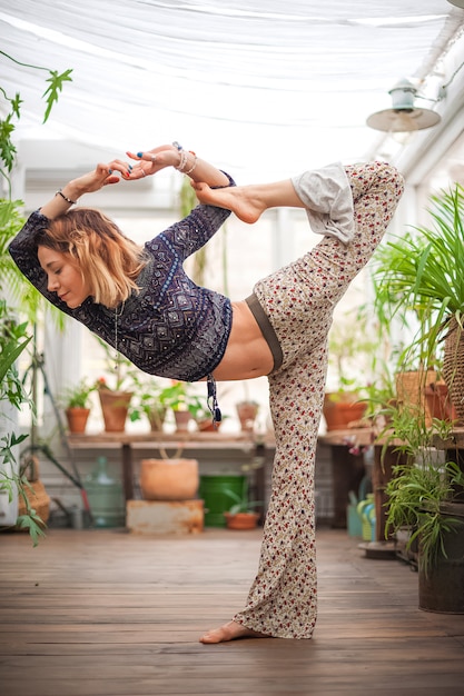 Concetto di esercizio domestico fitness. una donna pratica yoga e pilates a casa. casa ecologica. giungla urbana e yoga