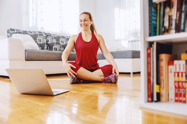 Photo fitness instructor sitting on the floor at home and explaining exercises to the student