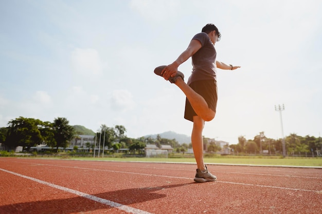 Fitness, jogging, running, exercise, lifestyle and healthy concept. The young man wore all parts of his body to prepare for jogging on the running track around the football field.