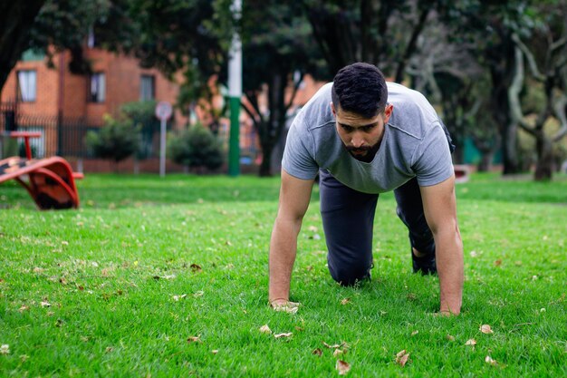 fitness jonge man doen stretchen om lichamelijke training te doen in een park in de stad