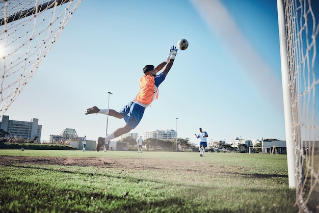 Fitness keeper of voetballer die een strafschop neemt in een wedstrijd of trainingswedstrijd op een toernooi Save back of mannelijke voetbalspeler die de bal schopt tijdens de oefening op het buitenveld of het veld in het stadion