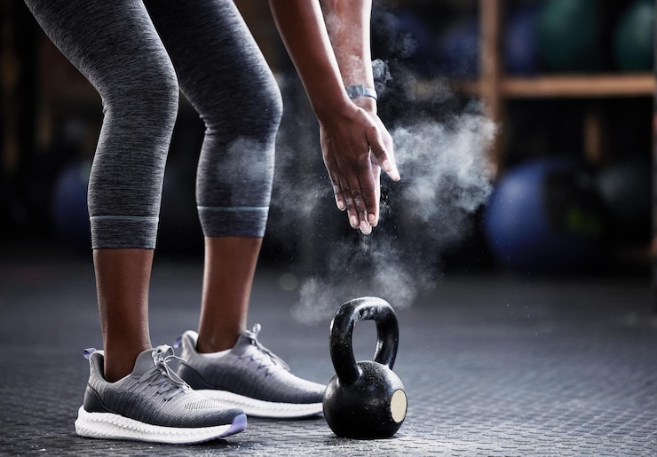 Photo fitness kettlebell or hands of woman with powder to start training workout or exercise for grip strength body builder floor or healthy athlete with chalk dust at gym ready for lifting weights