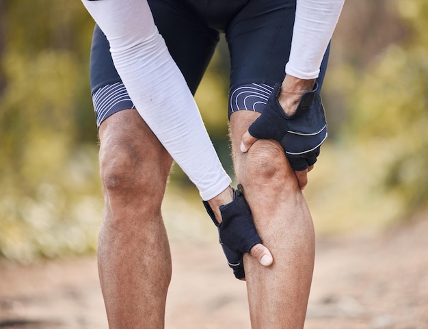 Fitness knee pain and man hands in forest with cycling sports or injury muscle or joint accident outdoor Leg arthritis or athlete with fibromyalgia emergency or cramps massage for osteoporosis