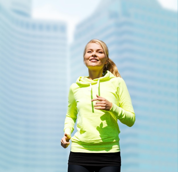 fitness and lifestyle concept - female runner jogging outdoors