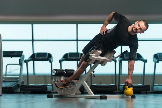 Fitness man aan het werk met waterkoker Bell In een sportschool Kettlebell-oefening