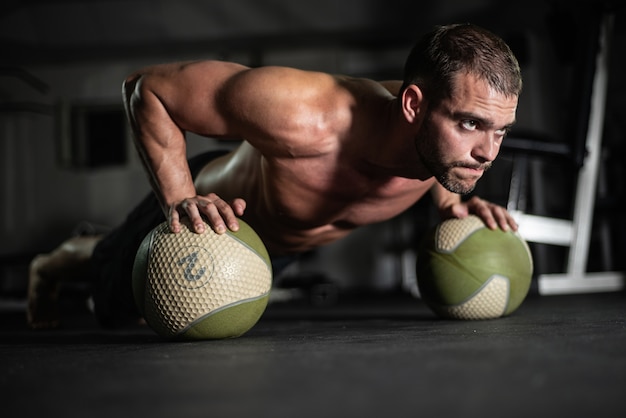 Fitness man doet push-ups op de ballen