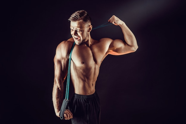 Fitness man exercising with stretching band