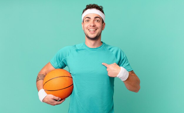 Fitness man feeling happy, surprised and proud, pointing to self with an excited, amazed look