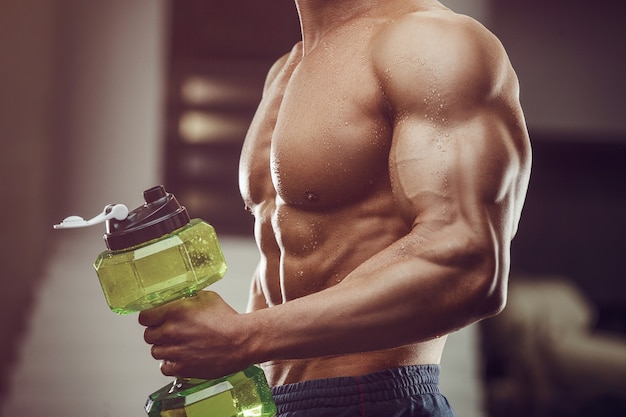 Fitness man in gym drinking water after workout. fitness and\
bodybuilding healthy background.