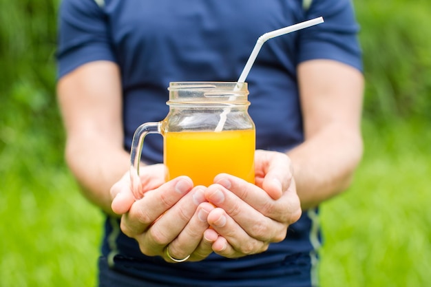 Foto uomo di forma fisica che tiene un bicchiere di succo d'arancia