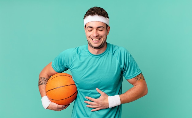 Fitness man laughing out loud at some hilarious joke, feeling happy and cheerful, having fun