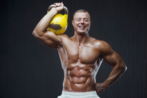 Fitness man oppompen van spieren met kettlebell