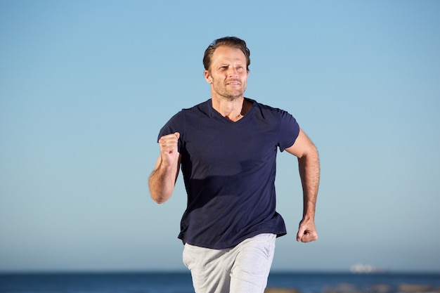 Fitness man running  outdoors by the sea