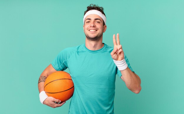 Fitness man smiling and looking friendly, showing number two or\
second with hand forward, counting down