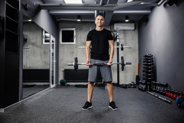 Fitness man in sportswear and good physical shape in an isolated indoor gym