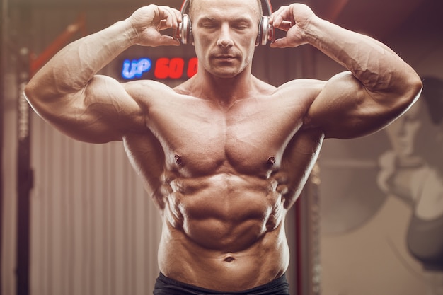 Fitness man with headphones at workout in gym