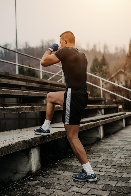 Allenamento di lavoro dell'uomo di forma fisica per la gamba all'aperto