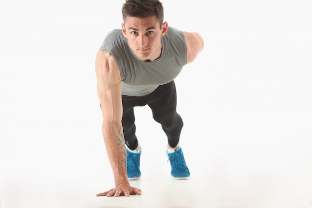 Fitness man wringing from the floor demonstrates good physical exercises isolated