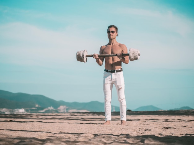 Fitness mannelijk model aan het trainen op het strand