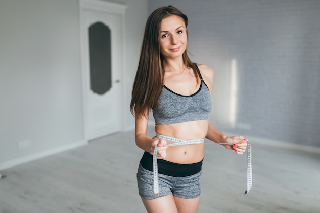 Fitness meisje met behulp van een tape mesure