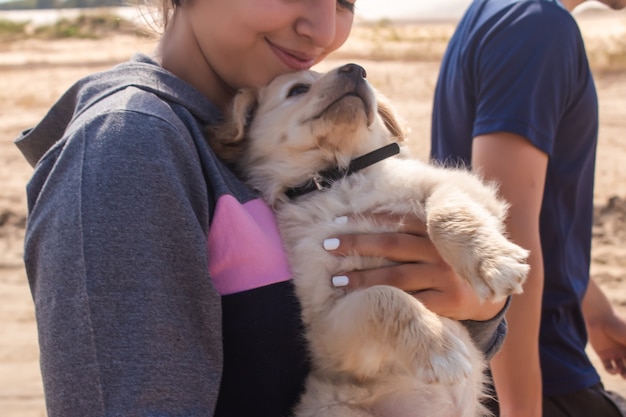 Fitness meisje neemt haar puppy mee naar het strand.