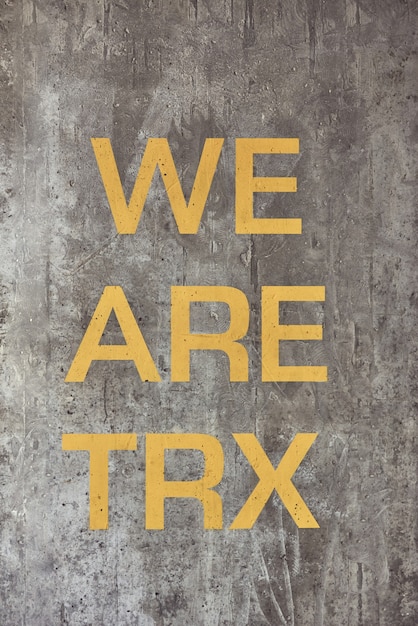 Fitness motivation quote we are trx written on grey beton wall at gym vertical shot