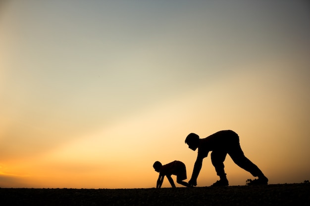 Fitness op silhouetzonsopgang De jongen het concept van de trainingwellness.