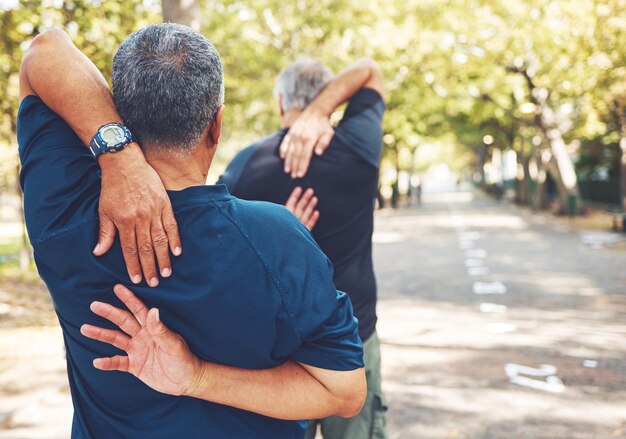 Fitness oudere mannen en stretchen in park klaar om te rennen en buiten te oefenen met handen en opwarmen achteraanzicht Lichaamstraining start rennen en sportmotivatie met volwassen hardloper en training