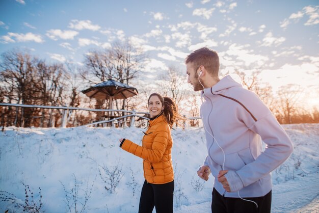 Fitness paar winter ochtend oefening op besneeuwde berg.